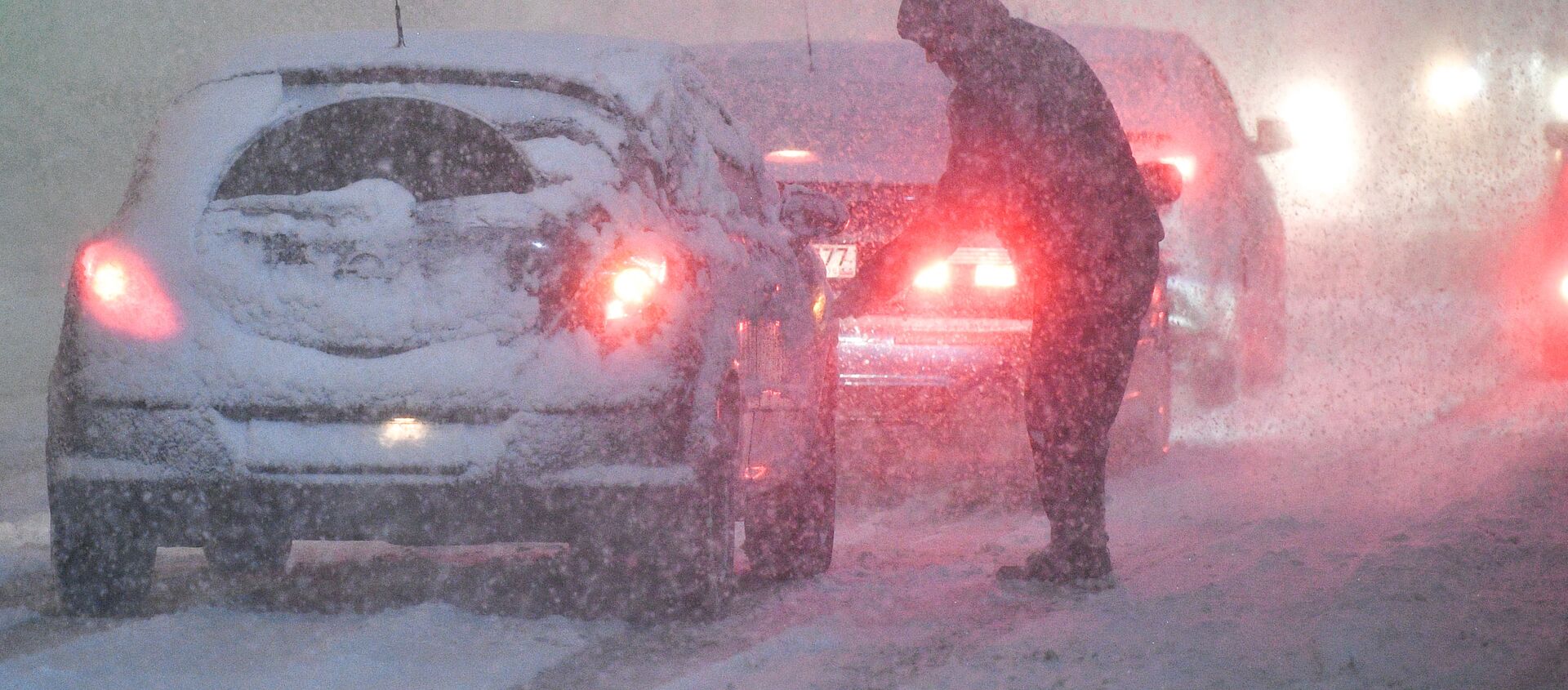 Мужчина очищает автомобиль от снега на одной из улиц в Подольске - 俄羅斯衛星通訊社, 1920, 01.02.2021