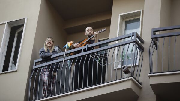 Люди играю на музыкальных инструментах на своем балконе в рамках музыкального флешмоба, который призван сплотить жителей различных городов на фоне карантина из-за коронавируса, Италия - 俄罗斯卫星通讯社