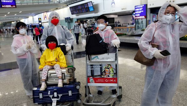 Люди в защитных масках и костюмах в международном аэропорту в Гонконге - 俄罗斯卫星通讯社