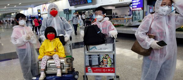 Люди в защитных масках и костюмах в международном аэропорту в Гонконге - 俄罗斯卫星通讯社
