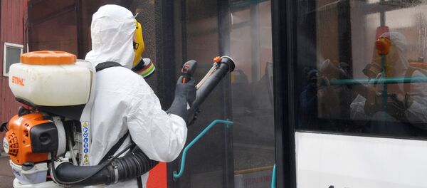 Сотрудники санитарных служб в защитных костюмах проводят обработку общественного транспорта - 俄罗斯卫星通讯社