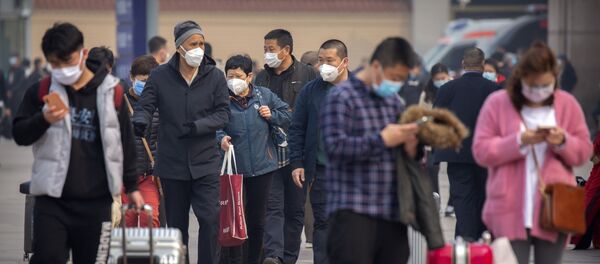 Туристы в масках возле вокзала в Пекине - 俄罗斯卫星通讯社