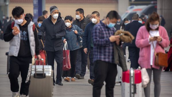 Туристы в масках возле вокзала в Пекине - 俄罗斯卫星通讯社