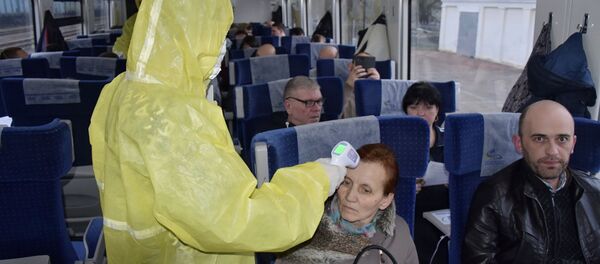 Украинский медработник проверяет температуру женщины, прибывшей из Польши на Украину Украинский медработник проверяет температуру женщины, прибывшей из Польши на Украину - 俄罗斯卫星通讯社