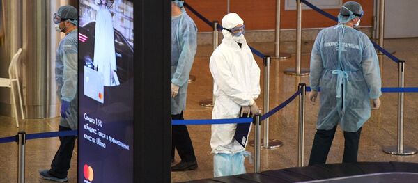 Медики в защитных костюмах в зоне прилета в аэропорту Шереметьево.  - 俄罗斯卫星通讯社