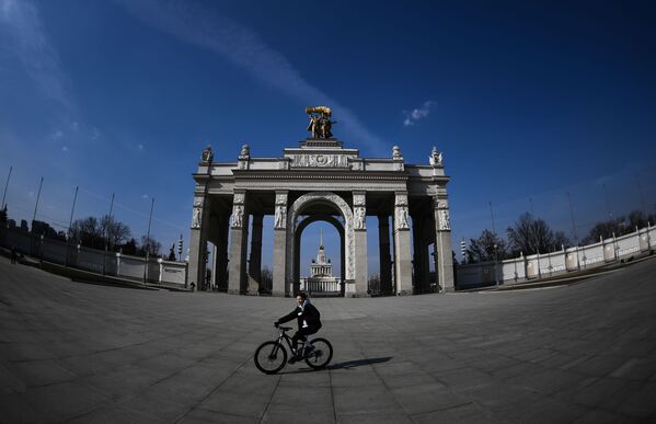 Велосипедист катается на площади перед закрытым входом на территорию ВДНХ в Москве - 俄羅斯衛星通訊社