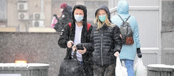 Молодые люди в медицинских масках на одной из улиц в Москве - 俄羅斯衛星通訊社