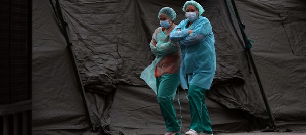Медицинский персонал в защитных масках и костюмах во время вспышки коронавирусна в Мадриде, Испания Медицинский персонал в защитных масках и костюмах во время вспышки коронавирусна в Мадриде, Испания - 俄罗斯卫星通讯社