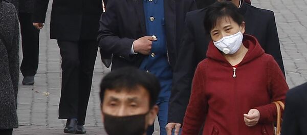 Прохожие в медицинских масках на одной из улиц Пхеньяна, Северная Корея Прохожие в медицинских масках на одной из улиц Пхеньяна, Северная Корея - 俄罗斯卫星通讯社