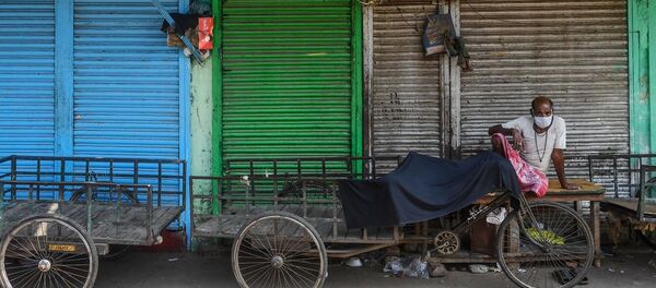 A daily labourer wearing a facemask waits near rickshaws for trucks to come for food commodities at a wholesale market during a 21-day government-imposed nationwide lockdown as a preventive measure against the COVID-19 coronavirus in Kolkata on March 26, 2020. A daily labourer wearing a facemask waits near rickshaws for trucks to come for food commodities at a wholesale market during a 21-day government-imposed nationwide lockdown as a preventive measure against the COVID-19 coronavirus in Kolkata on March 26, 2020. - 俄罗斯卫星通讯社