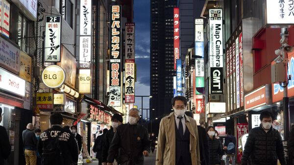 Люди в масках идут по улице в токийском районе Синдзюку, Япония - 俄罗斯卫星通讯社