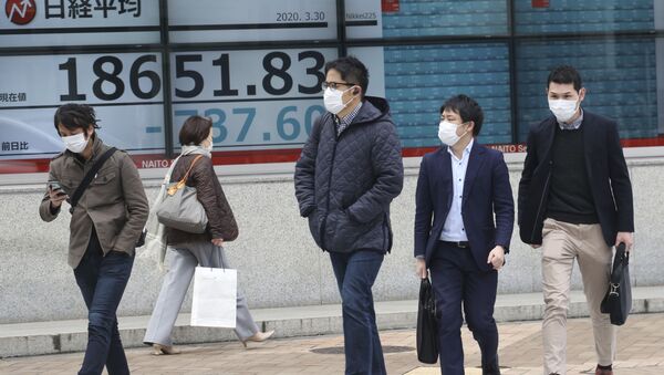 Люди в защитных масках проходят мимо электронного табло биржи ценных бумаг в Токио, Япония - 俄羅斯衛星通訊社