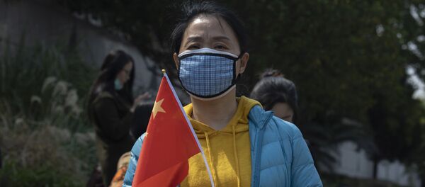 Девушка в медицинской маске с национальным флагом - 俄羅斯衛星通訊社