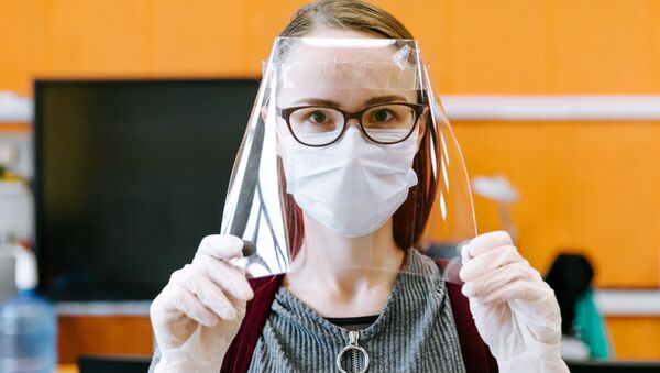 Девушка демонстрирует готовый лицевой экран для индивидуальной защиты глаз, дыхательных путей и лица медицинских работников в технопарке Кванториум. Новатория - 俄羅斯衛星通訊社