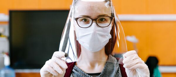 Девушка демонстрирует готовый лицевой экран для индивидуальной защиты глаз, дыхательных путей и лица медицинских работников в технопарке Кванториум. Новатория - 俄罗斯卫星通讯社