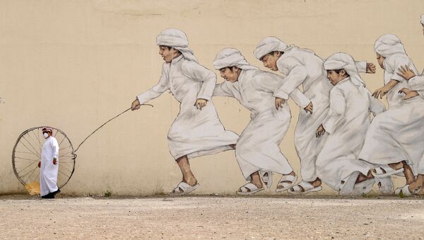 Мужчина в медицинской маске проходит мимо граффити в Дубае, ОАЭ - 俄罗斯卫星通讯社