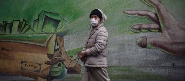 Местная жительница в Ухане, Китай, проходит на фоне стены с граффити - 俄罗斯卫星通讯社