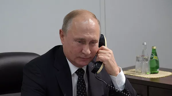 Президент РФ Владимир Путин во время разговора по телефону  - 俄罗斯卫星通讯社