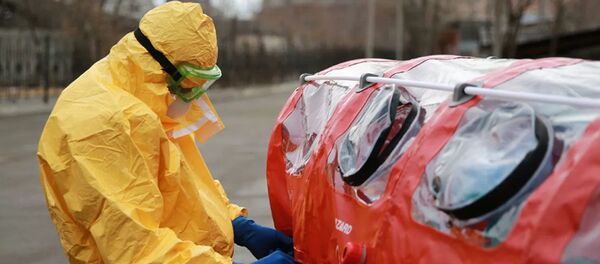 Врач бригады скорой помощи в защитном костюме готовит бокс для перевозки зараженных коронавирусом - 俄罗斯卫星通讯社