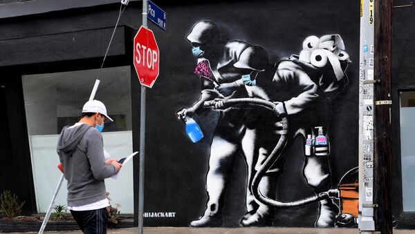 Прохожий напротив граффити, посвященного борьбе с коронавирусом, в Лос-Анджелесе - 俄罗斯卫星通讯社