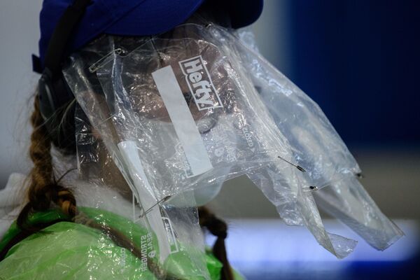 香港机场一名乘客为预防新冠病毒戴着医用口罩，脸上套着食品保鲜袋 - 俄罗斯卫星通讯社