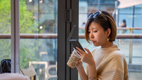 Китай Пекин весна девушка китаянка телефон кофе - 俄羅斯衛星通訊社