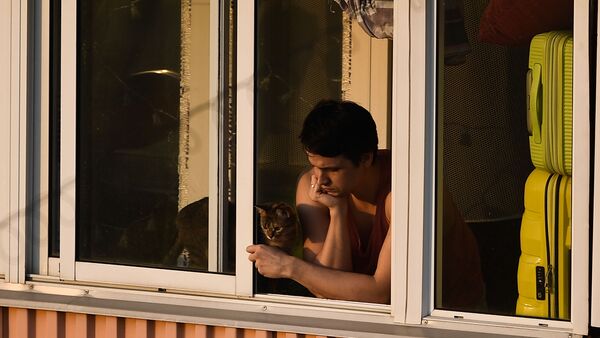 Молодой человек с кошкой на балконе многоквартирного дома в Москве - 俄罗斯卫星通讯社