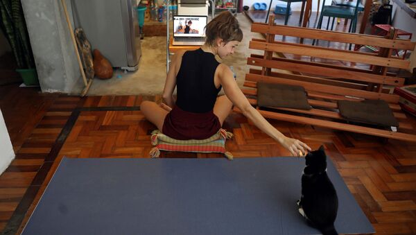 Инструктор по йоге со своей кошкой во время онлайн-урока у себя дома в Рио-де-Жанейро, Бразилия - 俄羅斯衛星通訊社