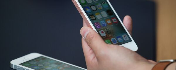 Мобильный телефон iPhone SE в руке - 俄罗斯卫星通讯社