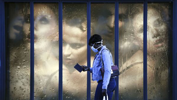 Женщина в медицинской маске на фоне витрины магазина в Париже, Франция - 俄罗斯卫星通讯社