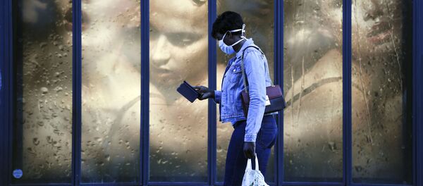 Женщина в медицинской маске на фоне витрины магазина в Париже, Франция - 俄羅斯衛星通訊社