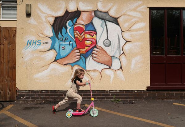 Девочка на самокате во время прогулки у граффити в Понтефракте - 俄罗斯卫星通讯社