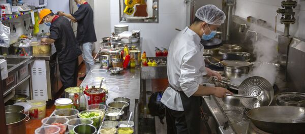 staff members wear face masks to protect against the spread of the new coronavirus as they work in the kitchen at Little Yunnan restaurant in Beijing - 俄罗斯卫星通讯社