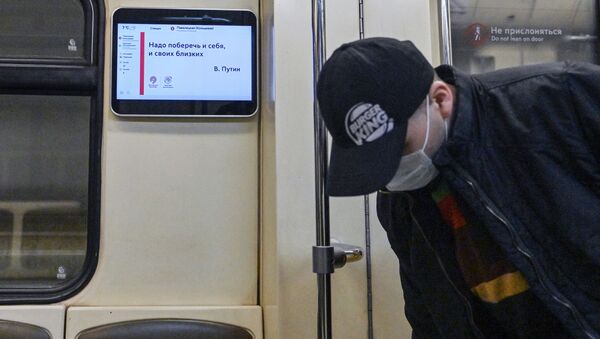 Мужчина в защитной маске в вагоне поезда Московского метрополитена - 俄罗斯卫星通讯社