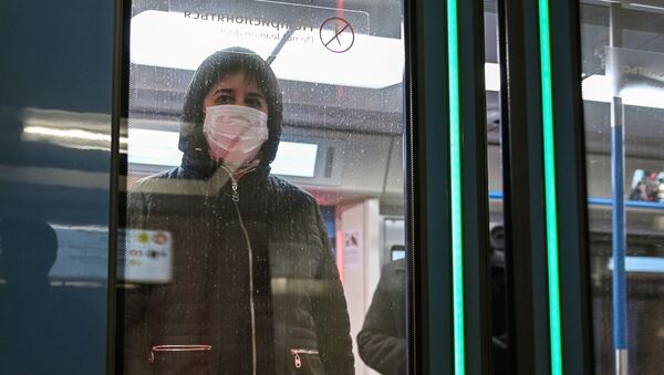 Женщина в защитной маске в вагоне поезда на станции метро Новокузнецкая в Москве - 俄羅斯衛星通訊社