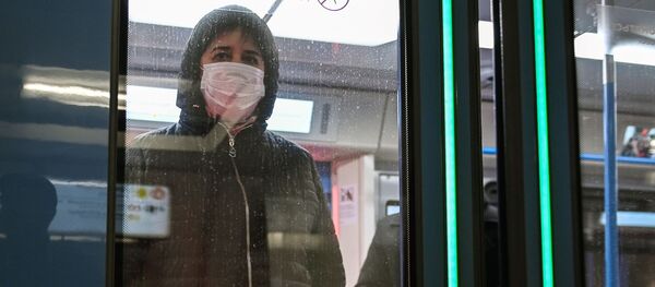 Женщина в защитной маске в вагоне поезда на станции метро Новокузнецкая в Москве - 俄罗斯卫星通讯社