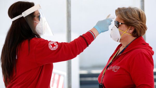 Волонтер Красного Креста проверяет температуру у посетительницы перед входом на рынок в Чистернино - 俄羅斯衛星通訊社