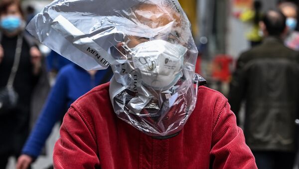 Велосипедист в защитной маске и с пластиковым пакетом на голове на одной из улиц Уханя, Китай - 俄罗斯卫星通讯社