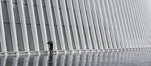 Человек с зонтом на фоне транспортного узла Oculus в Нью-Йорке во время режима ЧС - 俄罗斯卫星通讯社