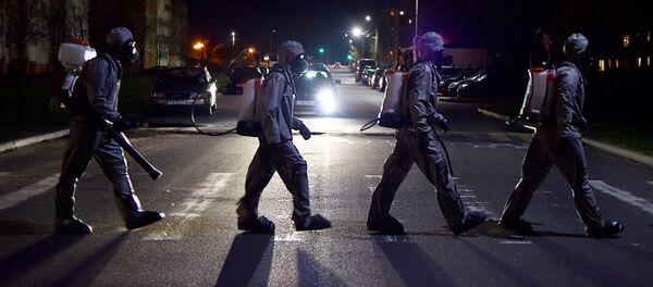 Белорусские военнослужащие в защитном снаряжении переходят дорогу после дезинфекции больницы под Минском - 俄罗斯卫星通讯社