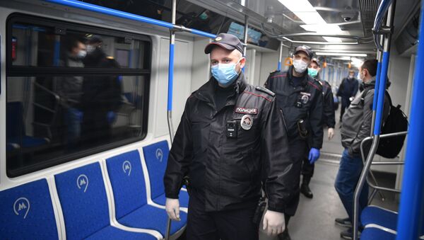 Сотрудники полиции в защитных масках в вагоне московского метро  - 俄罗斯卫星通讯社