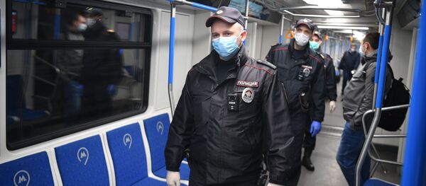 Сотрудники полиции в защитных масках в вагоне московского метро  - 俄罗斯卫星通讯社
