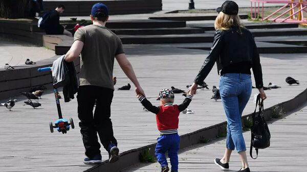 Семейная пара с ребенком гуляют по набережной - 俄羅斯衛星通訊社