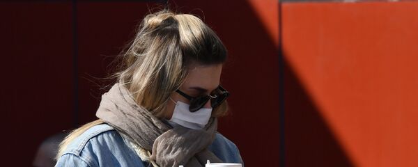 Девушка в защитной маске в Москве с кофе на вынос - 俄罗斯卫星通讯社