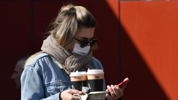 Девушка в защитной маске в Москве с кофе на вынос - 俄羅斯衛星通訊社