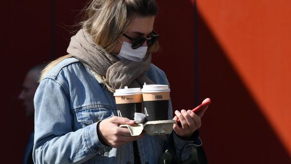 Девушка в защитной маске в Москве с кофе на вынос - 俄罗斯卫星通讯社