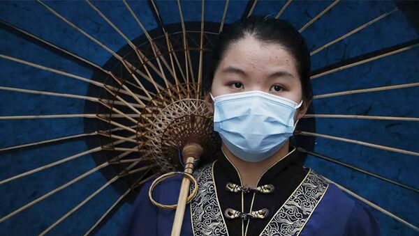 Китайская девушка в защитной маске и в традиционной одежде - 俄羅斯衛星通訊社