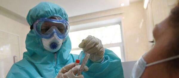 Медицинский работник в защитном костюме проводит забор биоматериала для анализа на коронавирус в городской поликлинике Москвы.  - 俄罗斯卫星通讯社