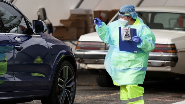 Медработник в защитном костюме во время тестирования водителей на наличие коронавируса в Сиднее  - 俄羅斯衛星通訊社