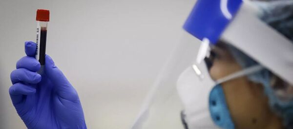 Медицинский работник держит в руках пробирку - 俄羅斯衛星通訊社